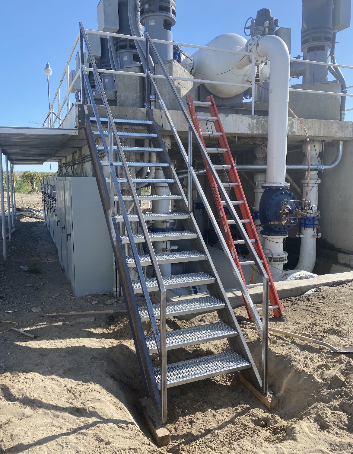 Structural steel stairs with welded stringers, grip treads, and guardrail at an industrial site in Idaho